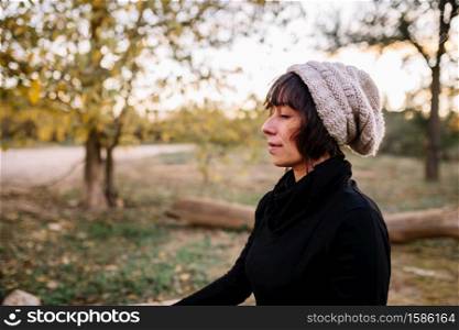 Woman practicing yoga and meditating on the park bench