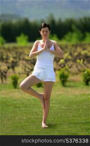 Woman practicing yoga in a field