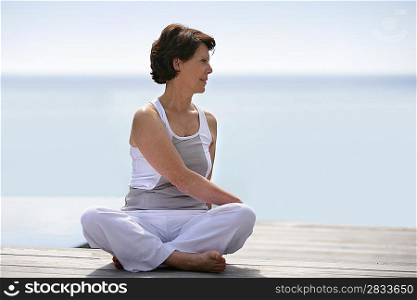 Woman practicing yoga on a deck