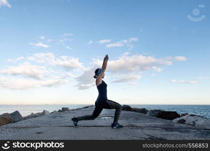 Woman practicing yoga on the beach on a cloudy day