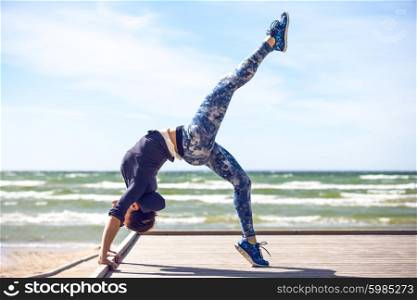 woman practicing yoga on the coast of sea, sunny day