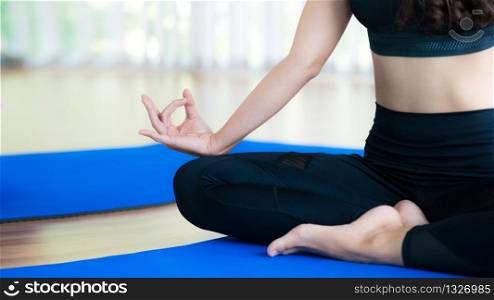 Woman practicing yoga pose in gym, close up view. Healthy lifestyle and wellness concept.