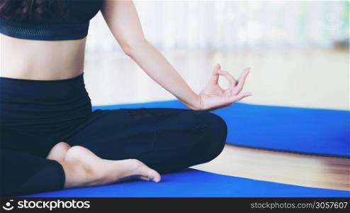Woman practicing yoga pose in gym, close up view. Healthy lifestyle and wellness concept.
