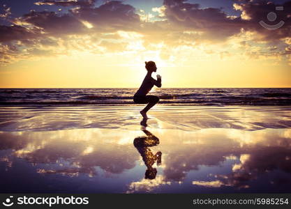 woman practicing yoga . silhouette of woman practicing yoga on the beach at sunset