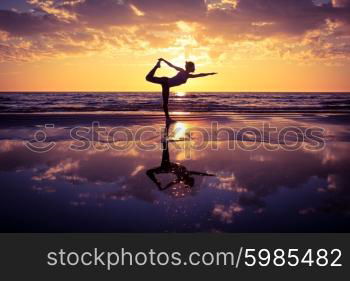 woman practicing yoga . silhouette of woman practicing yoga on the beach at sunset