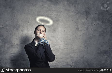 Woman praying for mercy. Young speechless businesswoman with tied hands and adhesive tape on mouth