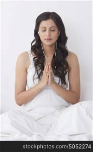 Woman praying while listening to music