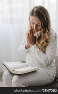 woman praying while reading from bible