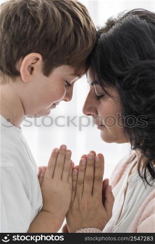 woman praying with her boy