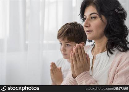 woman praying with her son copy space