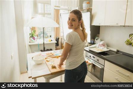 Woman preparing food for culinary blog. Photography equipment on kitchen