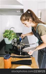woman preparing food saucepan electric stove