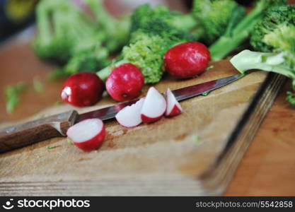 woman preparing healthy food salad with green and red vegetable and knife