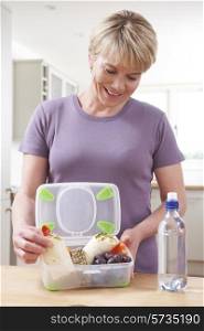 Woman Preparing Healthy Lunchbox In Kitchen