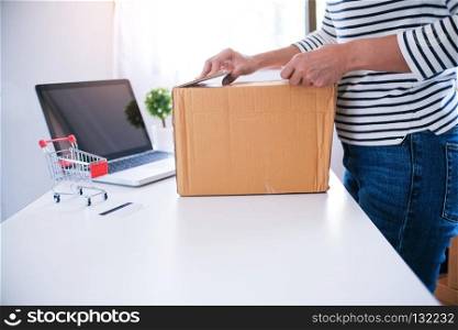 woman preparing package delivery box at home online order shopping