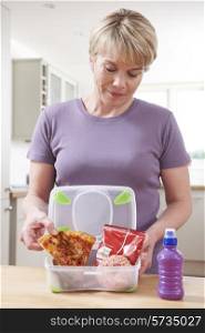 Woman Preparing Unhealthy Lunchbox In Kitchen