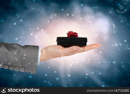 Woman presenting gift box. Close view of businesswoman hand holding gift box