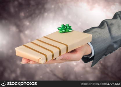 Woman presenting gift box. Close view of businesswoman hand holding gift box