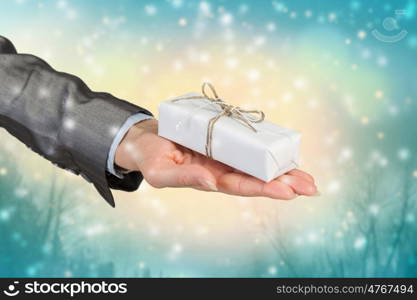 Woman presenting gift box. Close view of businesswoman hand holding gift box