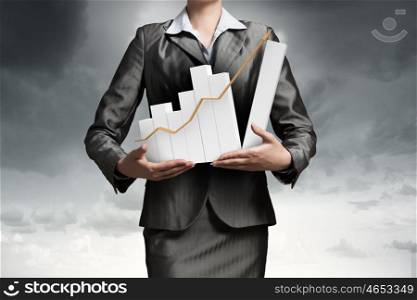 Woman presenting growth concept. Close up of businesswoman holding increasing graph in hands