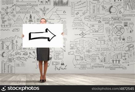 Woman presenting her idea. Young businesswoman showing banner with arrow and strategy sketch at background