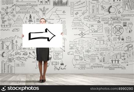 Woman presenting her idea. Young businesswoman showing banner with arrow and strategy sketch at background