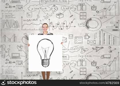 Woman presenting her idea. Young businesswoman showing banner with bulb idea and strategy sketch at background