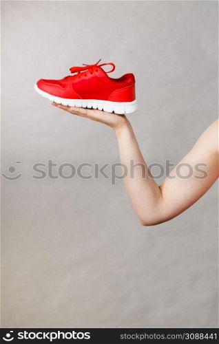 Woman presenting sportswear trainers red shoes, comfortable footwear perfect for workout and training.. Woman presenting sportswear trainers shoes
