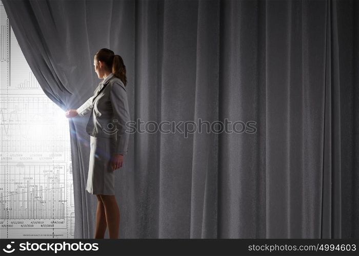 Woman presenting technologies. Young businesswoman opening curtain and presenting digital financial infographs