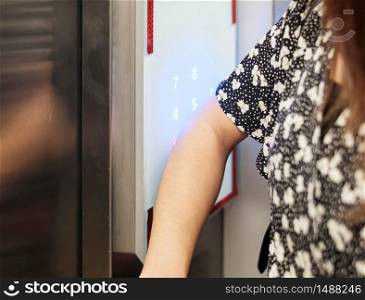 Woman press the elevator with elbow to protect coronavirus infection. social distancing, contactless, new normal and life after covid-19 pandemic