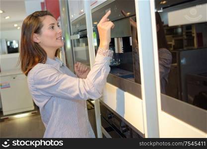 Woman pressing buttons on display oven