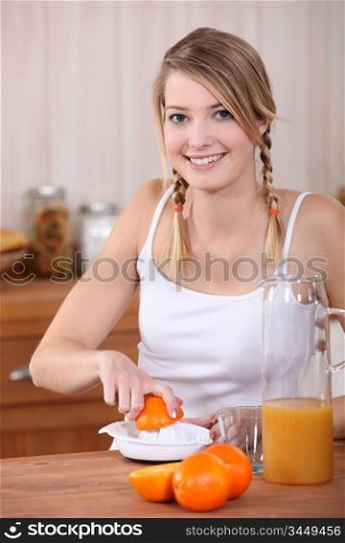 Woman pressing oranges.