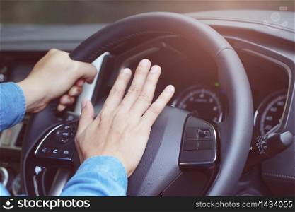 Woman pressing the horn while driving a car