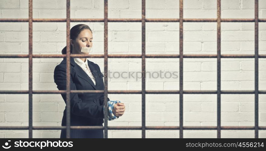 Woman prisoned in ward. Young speechless businesswoman in ward with tied hands and adhesive tape on mouth