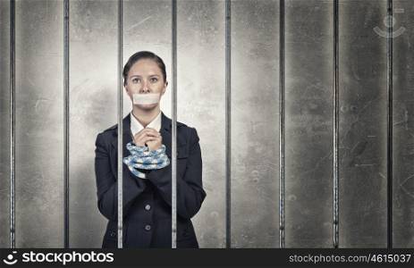 Woman prisoned in ward. Young speechless businesswoman in ward with tied hands and adhesive tape on mouth
