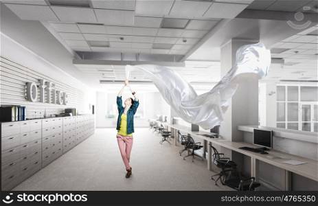 Woman pull white fabric. Young woman in office interior pulling white blank fabric