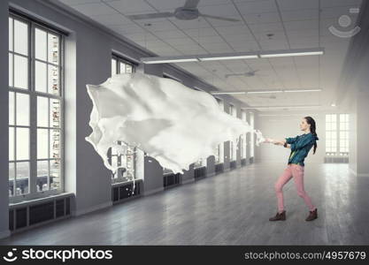 Woman pull white fabric. Young woman in office interior pulling white blank fabric