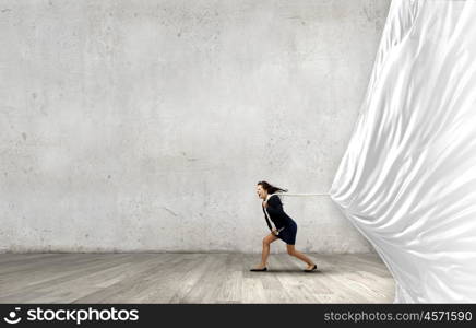 Woman pulling banner. Young determined businesswoman pulling white blank banner with rope