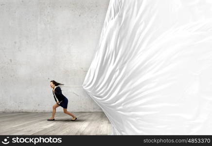 Woman pulling banner. Young determined businesswoman pulling white blank banner with rope