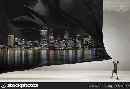 Woman pulling clothing banner. Young businesswoman in suit and bowler hat pulling curtain