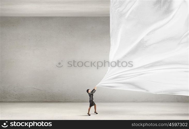 Woman pulling clothing banner. Young businesswoman in suit and bowler hat pulling curtain
