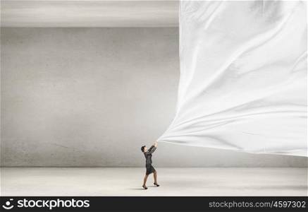 Woman pulling clothing banner. Young businesswoman in suit and bowler hat pulling curtain