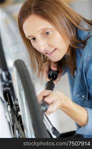 woman pumping on a bicycle wheel