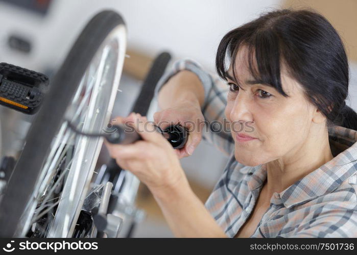 woman pumps up the tires of her bike