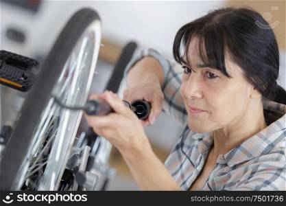woman pumps up the tires of her bike