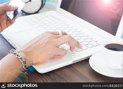 Woman push on laptop computer keyboard and holding credit card, Online shopping