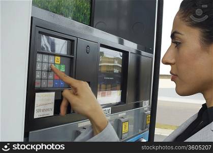 Woman pushing buttons on gas pump