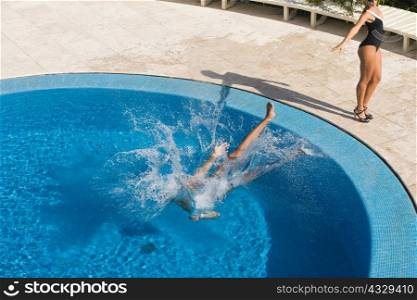 Woman pushing man in a swimming pool