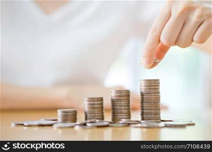woman put coins to stack of coins
