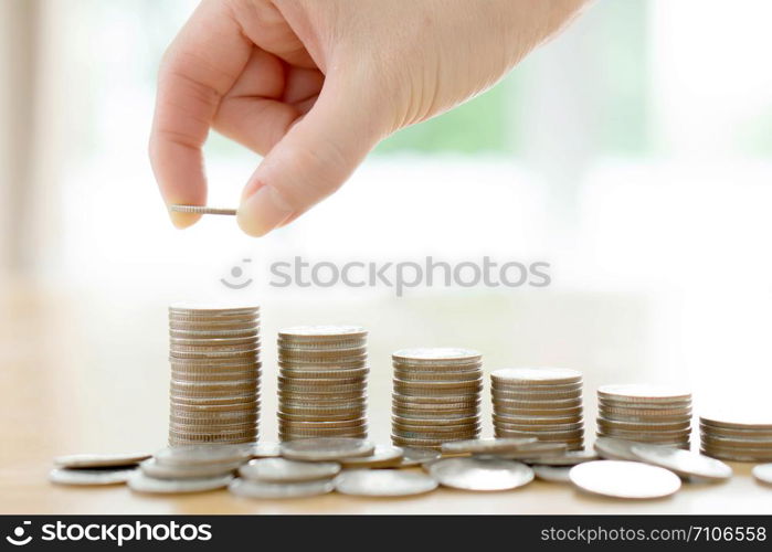 woman put coins to stack of coins